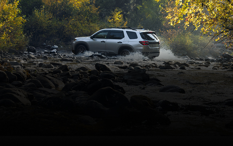 2026 Honda Pilot TrailSport in Solar Silver Metallic side angle crossing a river (Full-Size SUV).