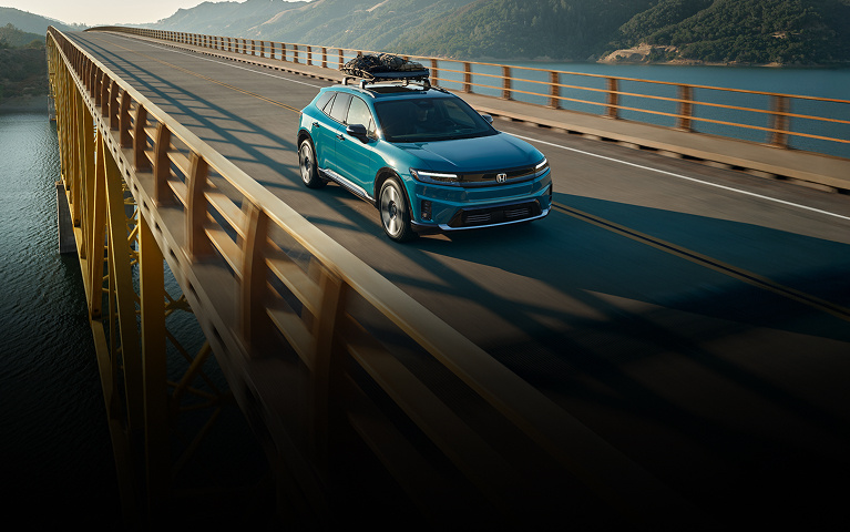 2026 Honda Prologue Elite in North Shore Pearl front 3/4 angle cruising trough a bridge (All-Electric SUV).