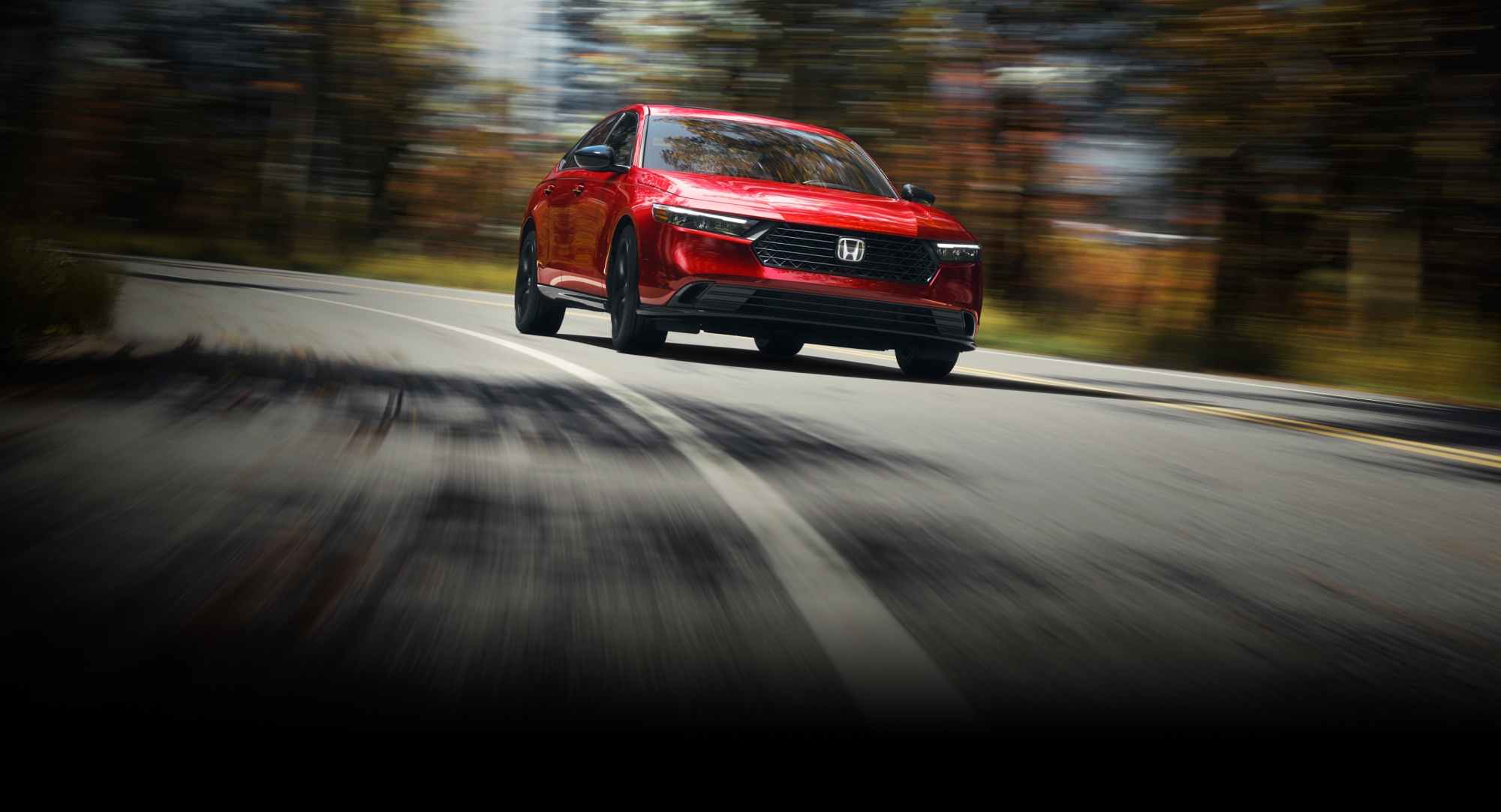 2026 Honda Accord driving in a forest environment taking the curve of the road.