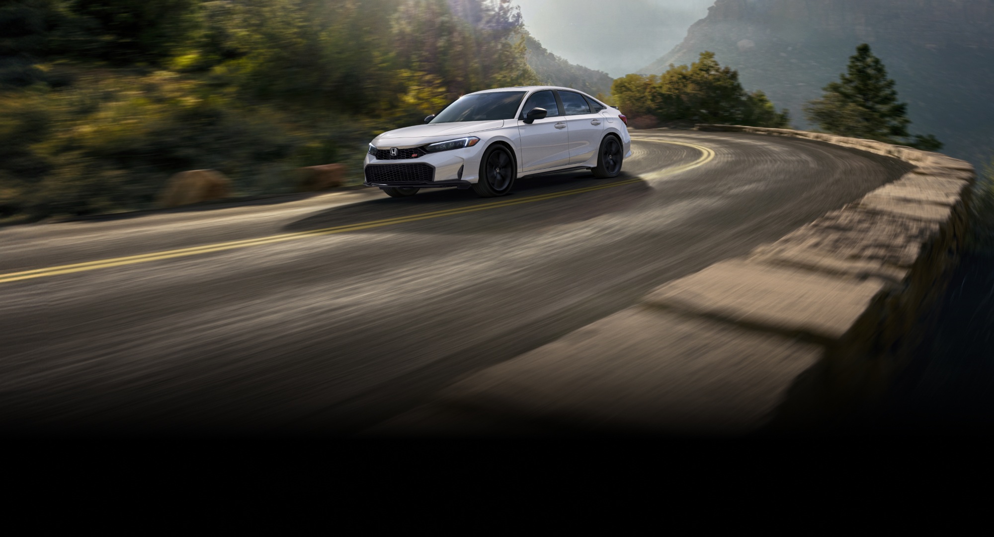 2026 Civic Si in Platinum white pearl driving through a curvy road in mountain and forest background with the sun rays peaking through