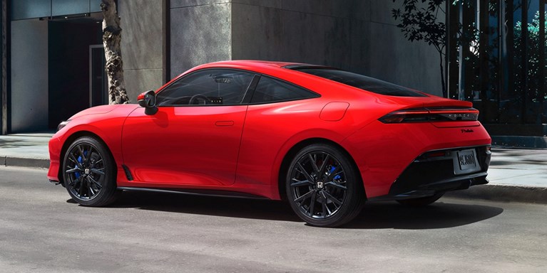 2026 Honda Prelude in Rallye Red, 3/4 rear view, parked alone the street in the down town.