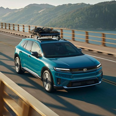 2026 Honda Prologue Elite in North Shore Pearl crossing a bridge in afternoon light, featuring Honda Genuine Accessories.