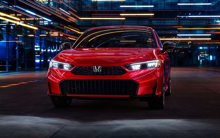 2026 Honda Civic Sedan Sport Touring Hybrid in Rallye Red front view with headlights on (Compact Sedan)