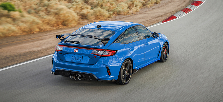 2026 Honda CR-V TrailSport Hybrid in Radiant Red Metallic front view driving on a canyon road (Compact Crossover SUV).